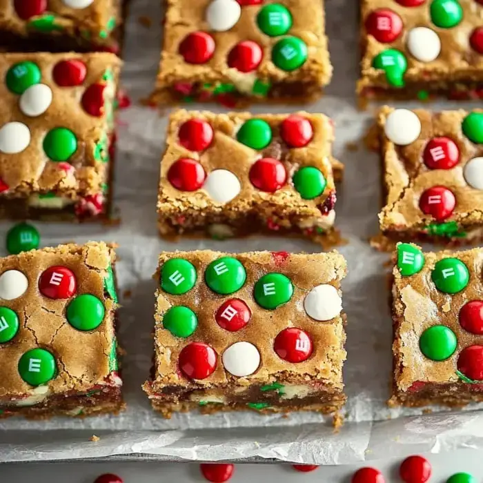 A close-up view of festive baked bars topped with red, green, and white candies arranged in a grid pattern.