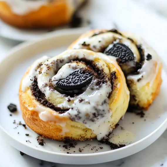 A plate with two donuts with Oreo cookies on top.