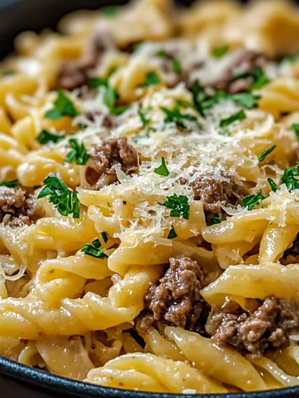 A bowl of pasta with meat and cheese.