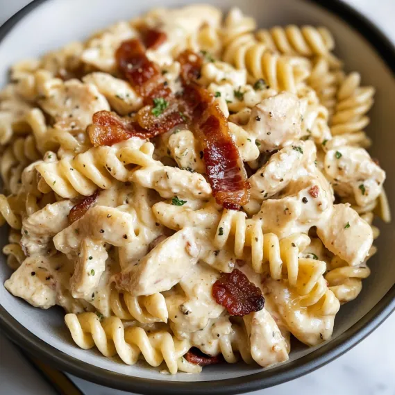 A bowl of pasta with chicken and bacon.