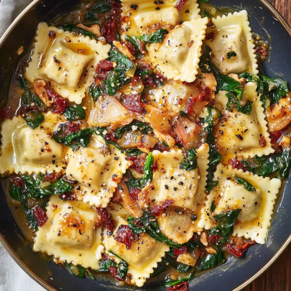 A plate of pasta with spinach and tomato sauce.