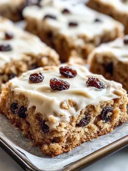 A square of cake with raisins on top.