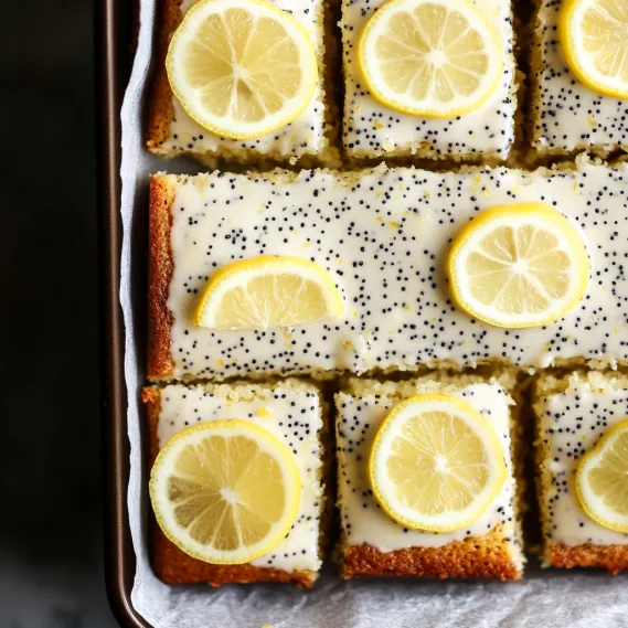 A tray of lemon squares with lemon wedges on top.