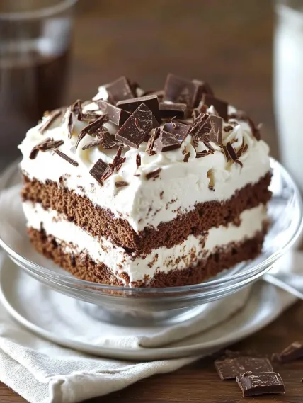 A slice of chocolate cake with white frosting.