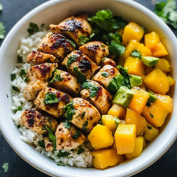A bowl of food with rice, chicken, and fruit.