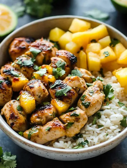 A bowl of food with rice and chicken.