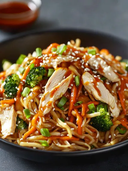 A bowl of chicken and broccoli with sauce.