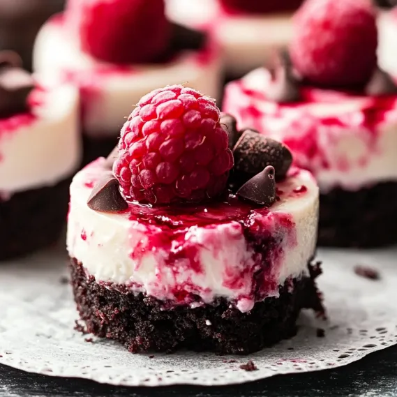 A slice of chocolate cake with a raspberry on top.