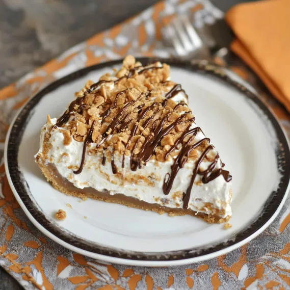 A slice of pie with chocolate and caramel drizzled on top.