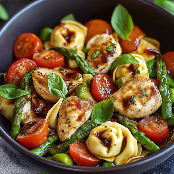 A bowl of food with tomatoes, asparagus, and chicken.