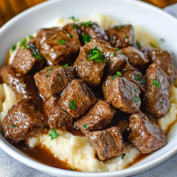 A bowl of meat and potatoes.
