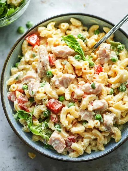 A bowl of pasta with meat and peas.