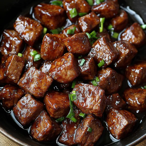 A bowl of beef with green onions.