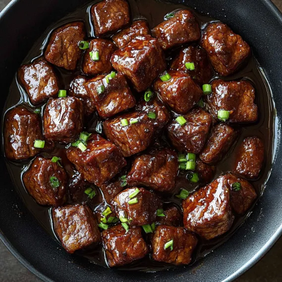 A bowl of beef in a brown sauce.