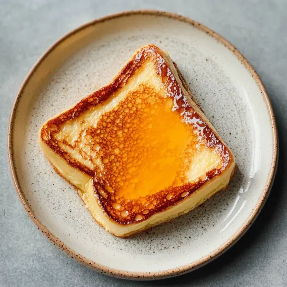 A piece of toast with a slice of cheese on top.