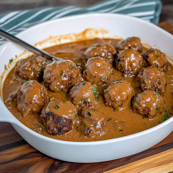 A bowl of meatballs in a brown sauce.