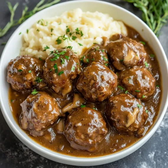 A bowl of meatballs with gravy.