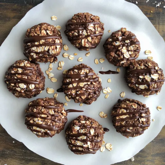 A plate of chocolate covered cookies with nuts.