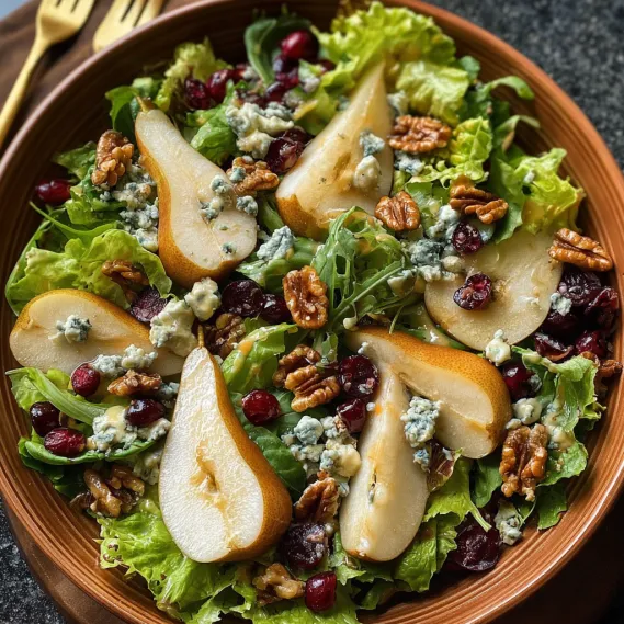 A bowl of salad with apples, walnuts, and blue cheese.