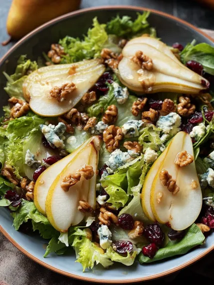 A plate of salad with apples and walnuts.