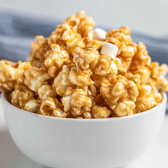 A bowl of popcorn with marshmallows on top.