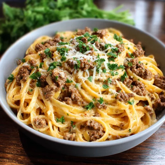 A bowl of pasta with meat and cheese.