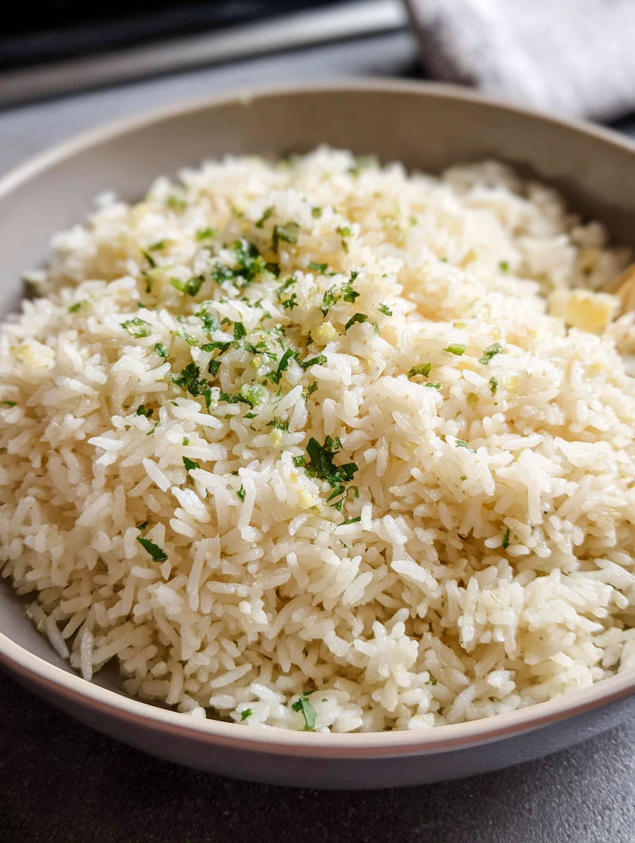 A bowl of rice with green herbs on top.