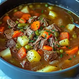 A savory beef stew featuring tender pieces of meat, carrots, potatoes, and green peas in a rich broth.