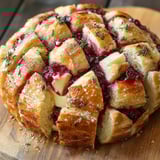 A loaf of bread with berries and cheese.