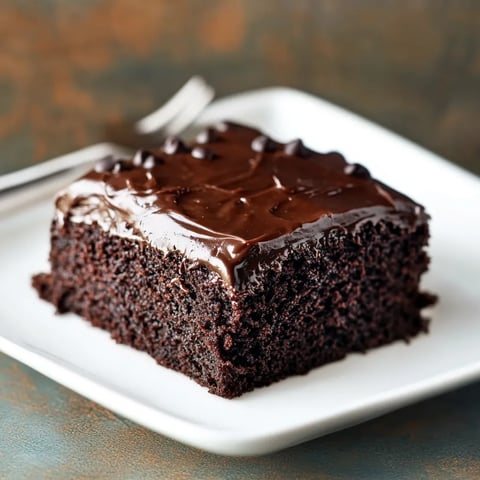 A piece of chocolate cake on a white plate.