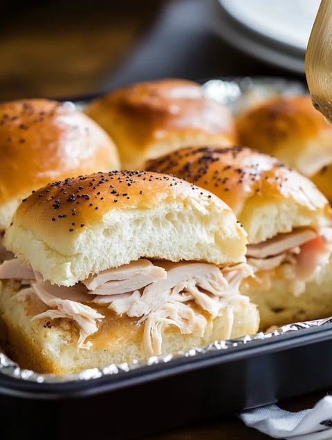 A tray of food with a sandwich and rolls.