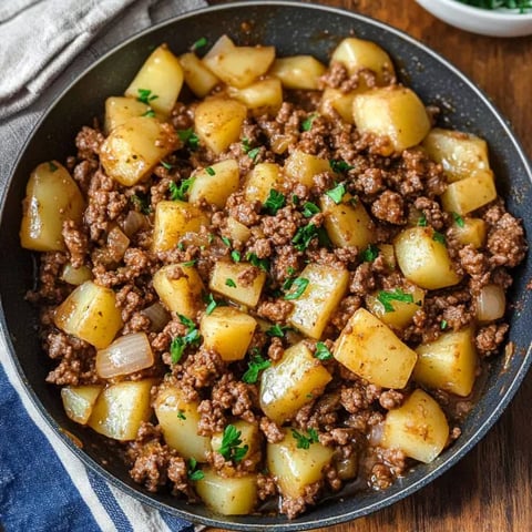 A bowl of food with potatoes and meat.