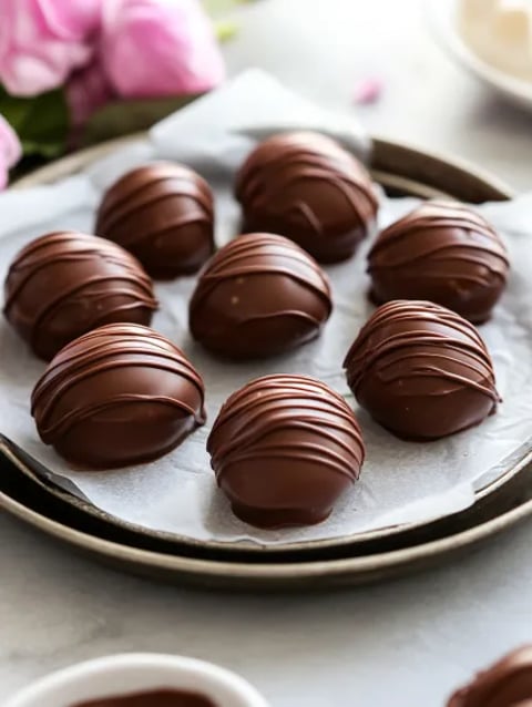Chocolate covered marshmallows on a tray.