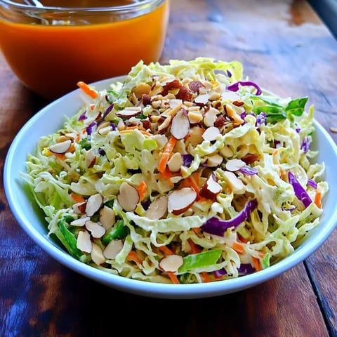 A bowl of coleslaw with nuts.