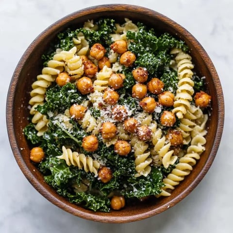 A bowl of pasta with chickpeas and spinach.
