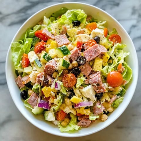 A bowl of salad with meat and vegetables.