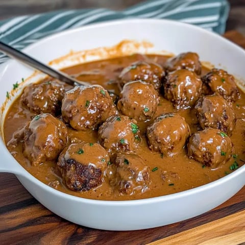 A bowl of meatballs in a brown sauce.