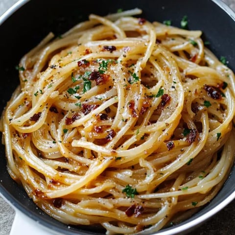 A bowl of pasta with cheese and herbs.