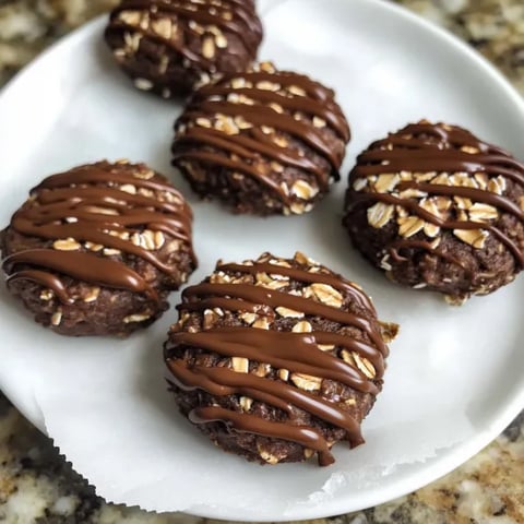 A plate of chocolate covered cookies.