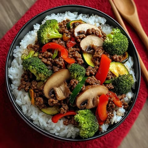 A bowl of food with mushrooms, broccoli, and peppers.