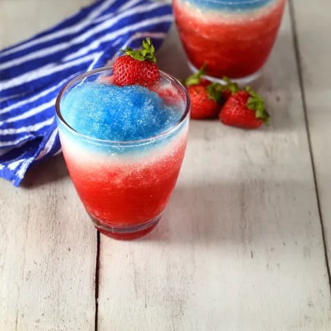 Two glasses of red, white and blue drinks.