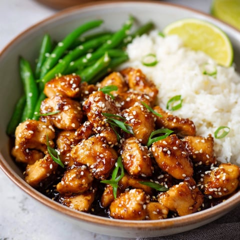 A bowl of chicken with rice and green beans.