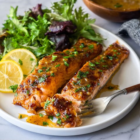 A plate of salmon with lemon and honey mustard.