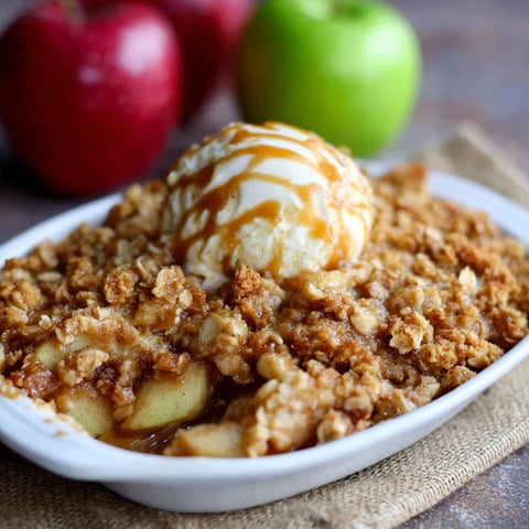A bowl of apple crisp with ice cream on top.