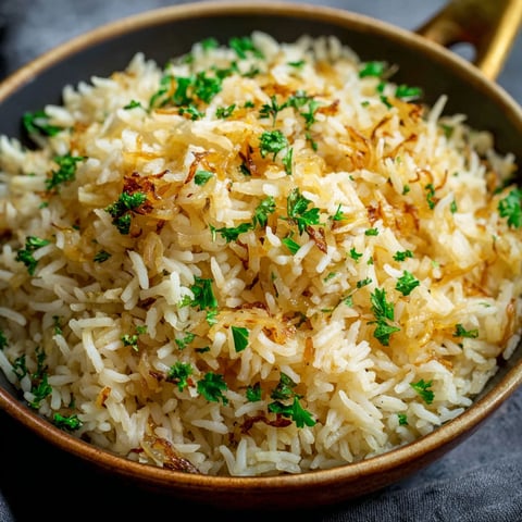 A bowl of rice with herbs on top.