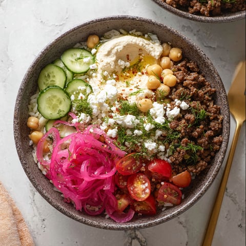 A bowl of food with a fork and a spoon.