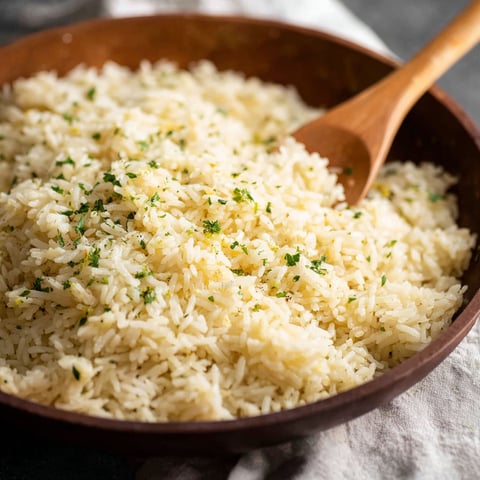 A wooden bowl filled with rice and herbs.
