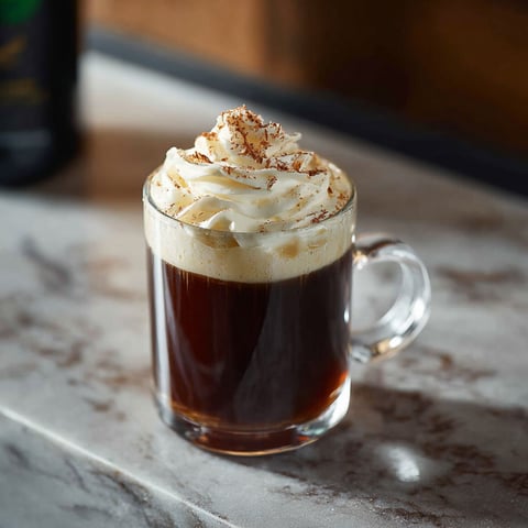 A glass of Irish coffee with whipped cream and a Jameson cocktail.