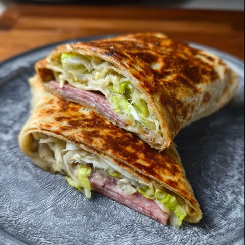 A Keto Italian Grinder Wrap is cut in half and placed on a plate.