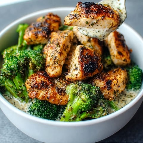 A bowl of grilled chicken and broccoli.